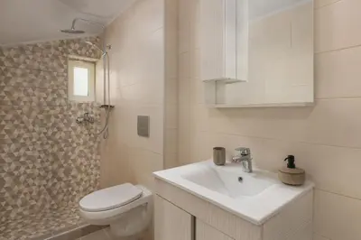 a bathroom with a sink and a toilet and a shower at Klinon Asti city apartment in Rhodes Town