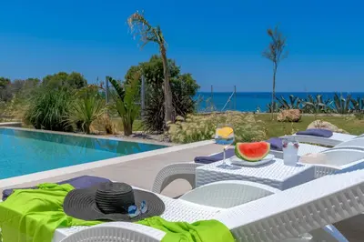 a table with a slice of watermelon on it next to a pool at Panaxia Villas in Theologos