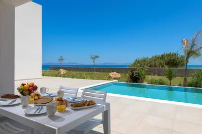 a table with food on it next to a swimming pool at Panaxia Villas in Theologos