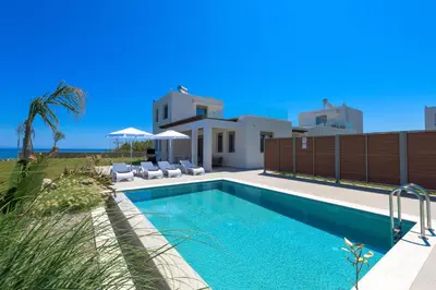 a swimming pool in front of a villa at Panaxia Villas in Theologos