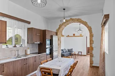 a kitchen and dining room with a table and an archway at Alonia Traditional House in Malona in Malona Village