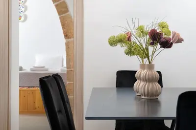 a dining room table with a vase of flowers on it at Antica Casa Dei Nonni in Archangelos