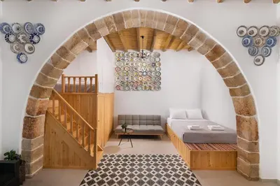 an archway in a room with a bed and plates on the wall at Antica Casa Dei Nonni in Archangelos