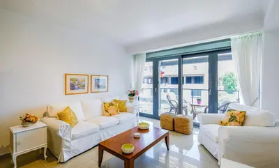 a living room with two white couches and a table at Grace Luxury Apartment next to Old Town in Rhodes Town