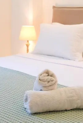 a pile of towels sitting on a bed at Grace Luxury Apartment next to Old Town in Rhodes Town