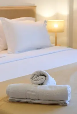 a bed with a rolled up towel on it at Grace Luxury Apartment next to Old Town in Rhodes Town