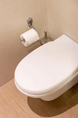 a white toilet in a bathroom with a roll of toilet paper at Grace Luxury Apartment next to Old Town in Rhodes Town