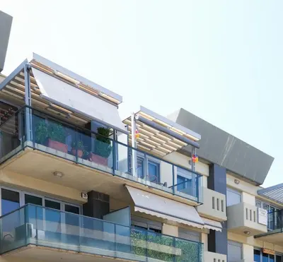 an apartment building with a balcony with blue windows at Grace Luxury Apartment next to Old Town in Rhodes Town