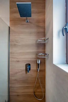 a bathroom with a television on a wooden wall at flower veranda 1st floor app in Rhodes Town