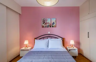 a bedroom with a bed with a purple wall at flower veranda 1st floor app in Rhodes Town