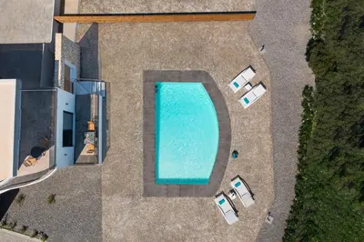an overhead view of a swimming pool with lounge chairs at Ventus Villas in Koskinou