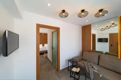 a living room with a couch and a television at Ventus Villas in Koskinou