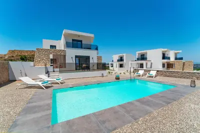 a villa with a swimming pool in front of a house at Ventus Villas in Koskinou