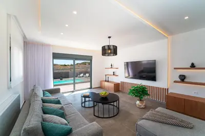 a living room with a couch and a tv at Ventus Villas in Koskinou