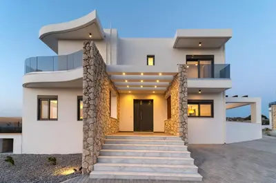 a white house with a staircase in front of it at Ventus Villas in Koskinou