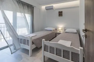a bedroom with two beds and a balcony at Diorisa House in Lardos