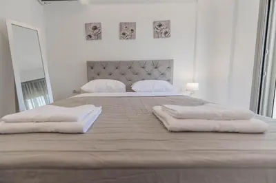 a white bedroom with two beds with white pillows at Diorisa House in Lardos