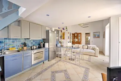a kitchen with blue cabinets and a living room at Casa Di Rodi in Rhodes Town