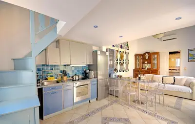 a kitchen with blue cabinets and a kitchen island with bar stools at Casa Di Rodi in Rhodes Town