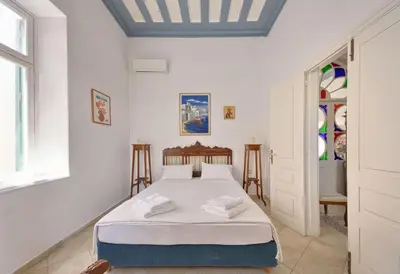 a white bedroom with a bed and a window at Casa Di Rodi in Rhodes Town