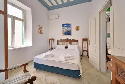 a bedroom with a bed with white sheets at Casa Di Rodi in Rhodes Town