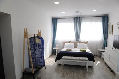 a bedroom with a bed and two windows at El Angel by Ntinos in Kremasti