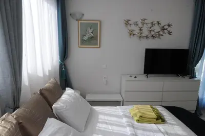 a bedroom with a bed with a tv on a dresser at El Angel by Ntinos in Kremasti