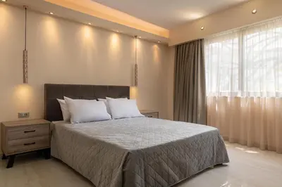 a bedroom with a large bed and a window at Lampraki Luxury Apartments in Rhodes Town