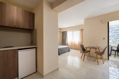 a kitchen and living room with a bed and a table at Lampraki Luxury Apartments in Rhodes Town