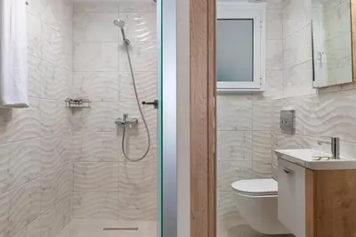 a bathroom with a shower with a toilet and a sink at Lampraki Luxury Apartments in Rhodes Town