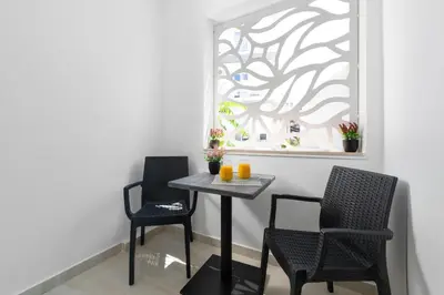 two chairs and a table in a room with a picture at Lampraki Luxury Apartments in Rhodes Town
