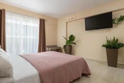 a bedroom with a bed and a flat screen tv at Lampraki Luxury Apartments in Rhodes Town