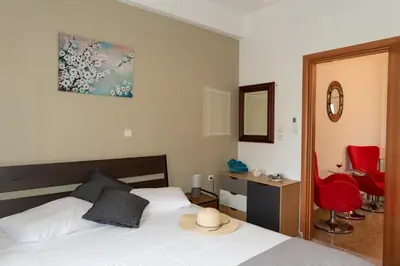 a bedroom with a bed and a desk and red chairs at Anna's house in Rhodes Town