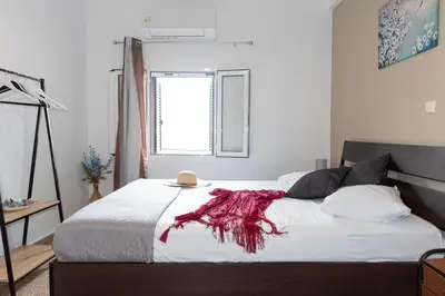 a bedroom with a bed with a red blanket on it at Anna's house in Rhodes Town