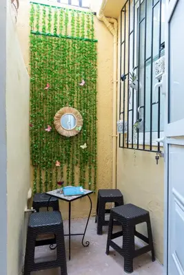 a patio with chairs and a table and a wall with flowers at Anna's house in Rhodes Town