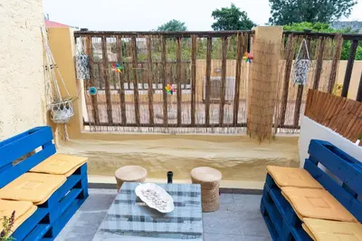 a patio with two blue benches and a table at Anna's house in Rhodes Town