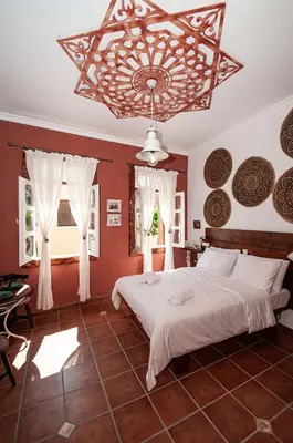 a bedroom with a large bed and a chandelier at Tango Suites in Rhodes Town