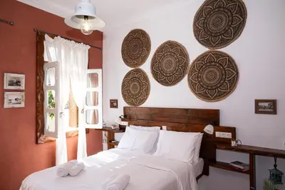 a bedroom with a bed and some plates on the wall at Tango Suites in Rhodes Town