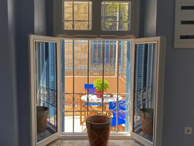 a room with a window with a view of a balcony at Arsanas in Symi