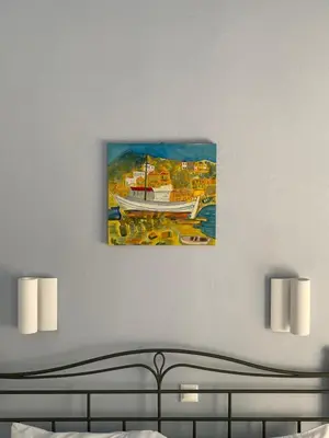 a painting of a boat on a wall above a bed at Arsanas in Symi