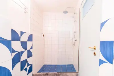 a bathroom with a shower with blue and white tiles at Arsanas in Symi