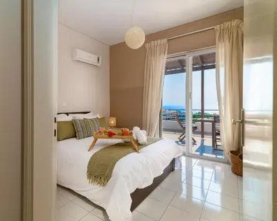 a bedroom with a bed with a view of the ocean at Harama House - Seaview City Apt. in Rhodes Town