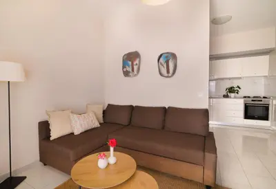 a living room with a brown couch and a table at Harama House - Seaview City Apt. in Rhodes Town