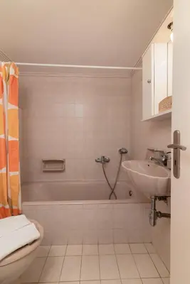 a bathroom with a tub and a sink and a toilet at Harama House - Seaview City Apt. in Rhodes Town