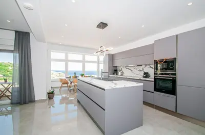 a kitchen with white appliances and a large window at Agnanti Sea View Villa in Koskinou