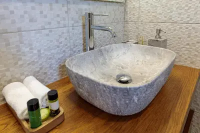 a bathroom with a large marble sink on a wooden floor at Bluebell House Halki in Halki
