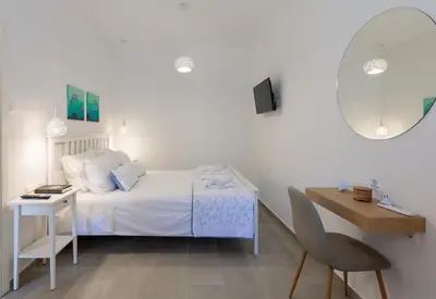 a bedroom with a bed and a table and a mirror at Bluebell House Halki in Halki