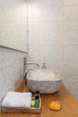 a bathroom with a stone sink and a mirror at Bluebell House Halki in Halki