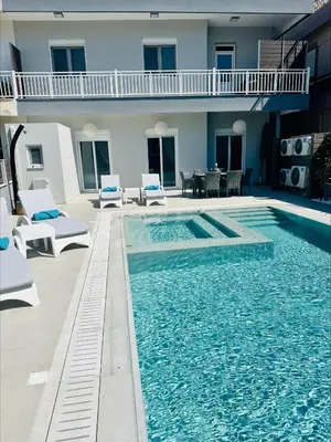 a swimming pool with chairs and a house at Flev's Luxury House with pool in Kremasti