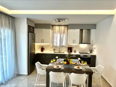 a kitchen with a table and chairs and a kitchen with aktop at Flev's Luxury House with pool in Kremasti